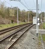vom Bahnsteig Hergenrath ist die Bahngrenze SNCB/DB zu sehen, im Hintergrund die Schilder B (durchgestrichen) und DB.