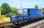 Ein blauer zweiachsiger Flachwagen im Bauzugdienst mit Werkzeugcontainer der Fa.