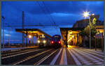 Zur blauen Stunde treffen sich am 23.02.2024 ein Hitachi Blues HTR 412 und ein ETR 104 vor dem historischen Empfangsgebäude des Bahnhofs Taormina-Giardini.