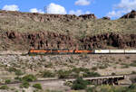 Etwas südöstlich von Kingman, AZ, bietet die Historic Route 66 sehr gute Fotostellen in der fantastischen Landschaft: Drei BNFS-Loks ziehen einen Güterzug in der roten Felswüste