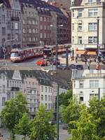 Ein Blick von der S-Bahn-Station Düsseldorf-Oberbilk auf die Kreuzung Siegburger Straße/Oberbilker Allee: Oben verlässt ein GT8SU-Doppel die oberirdische Haltestelle Siegburger