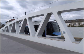 Hinter Fachwerk und Maschendraht -    Eine Avenio M-Tram auf der neuen Ulmer Kienlesbergbrücke.