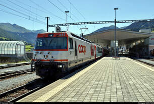 Ge 4/4 III 641  Maienfeld , mit Werbung für die Coop Genossenschaft, steht im Startbahnhof Disentis/Mustér (CH) auf Gleis 3.