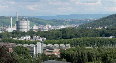 Über eine Fahrzeughalle -     ...des Abstell- und Wartungsbahnhofes Rosenstein in Stuttgart geht der Blick ins Neckartal bis zu der blauen Wand der Schwäbischen Alb.