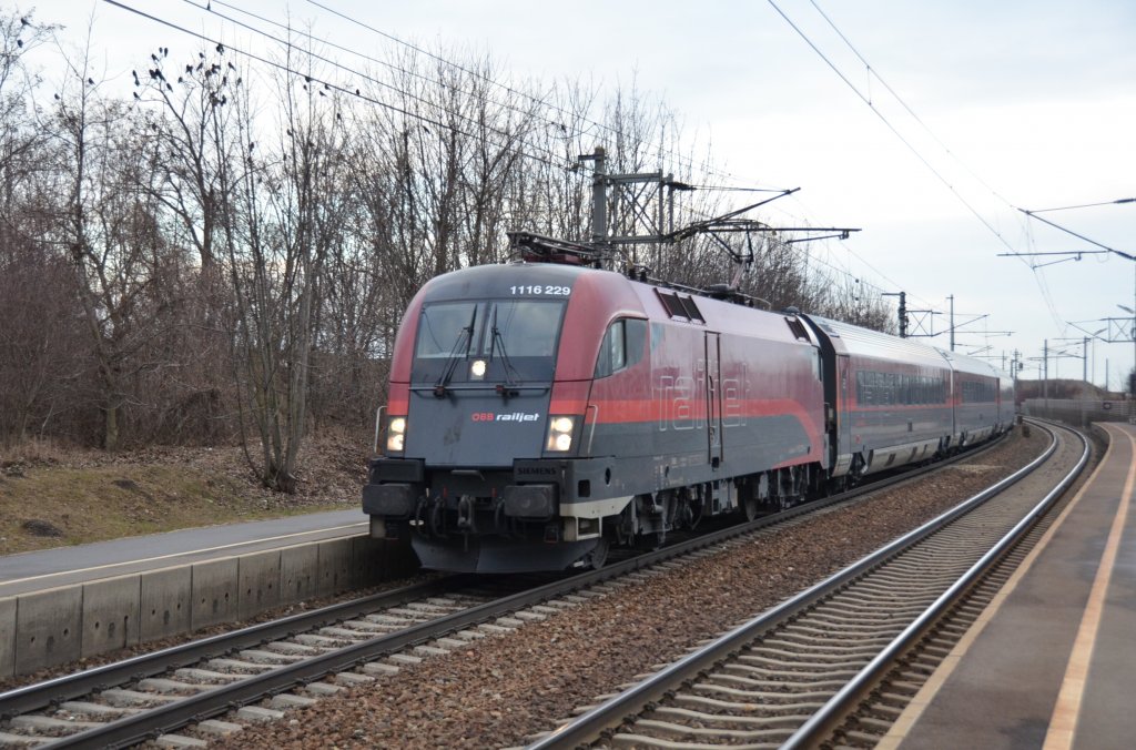 1116 229 eilt mit dem RJ65 von Wien West nach Budapest-Keleti-pu durch die Haltestelle Rannersdorf-Lanzendorf nach Ungarn. 18.2.2012