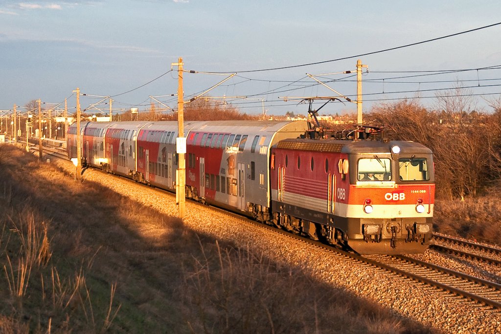 1144 069 im allerletzten Sonnenlicht des Tages mit R 2353. Die Aufnahme enstand am 07.03.2013 zwischen Helmahof und Deutsch Wagram.