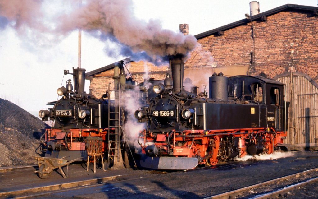 99 1586-9 und 99 1574-5 an einem schnen und kalten Dezembermorgen 1989 vor dem Mgelner Lokschuppen.