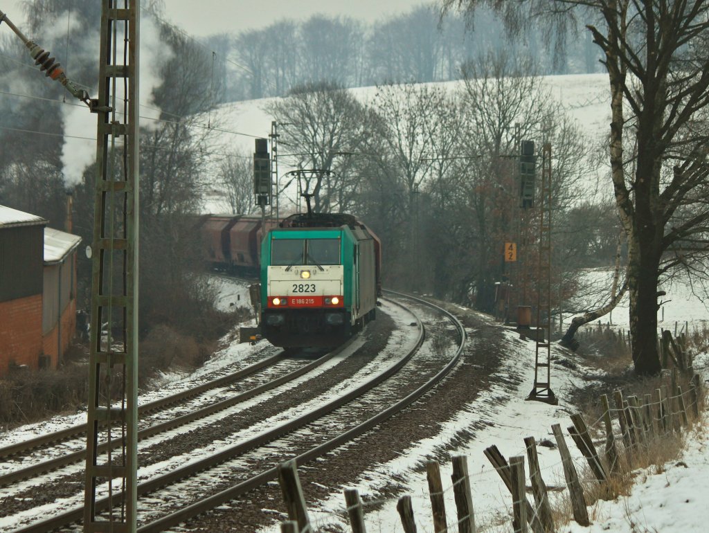 Bei saukalten Temperaturen zieht Cobra 186 215 (2823) am 09.02.2012 einen Getreidezug durch die letzte Kurve der Montzenrampe vor dem Gemmenicher Tunnel von Aachen West nach Belgien. Die Schienen scheinen sehr schmierig zu sein, man kann das Schleudern der Lok hren.