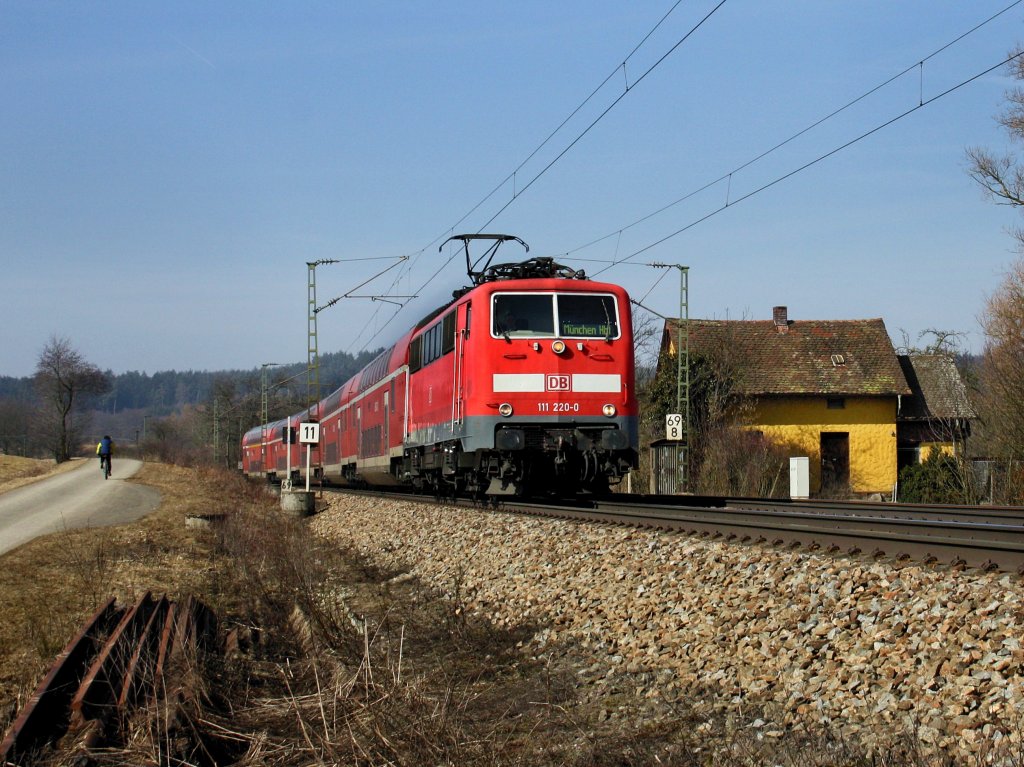 Die 111 220 am 05.03.2011 mit einem RE nach Mnchen unterwegs bei Plling. 