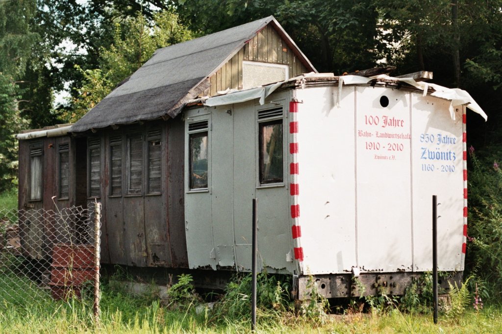 Dieser schsische Abteilwagenkasten steht in der einzigen Schrebergartenanlage hinter dem Bahnhof Zwnitz an der Ausfahrt nach Aue.Zur Zeit wird eine notdrftige Reparatur am Dach ausgefhrt,was allerdings ohne Strom schwierig ist.Da die DB AG diesen im gesamten Bahnhof,sowie in dem dahinter liegenden Gelnde (inclusive Schrebergarten) abgeschaltet hat.Auskunft des Besitzers!
Aufnahme 27.07.2010