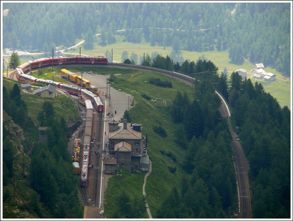 Full house in Alp Grm. Es kreuzen sich BerninaExpress 973 und R1644, beide mit Allegra, den Rest der Geleise beansprucht der Bahndienst. Die Sonne hat mir an diesem Tag arg zugesetzt, haben sich die Wolkenlcken doch im Sekundentakt verschoben. (14.07.2010)