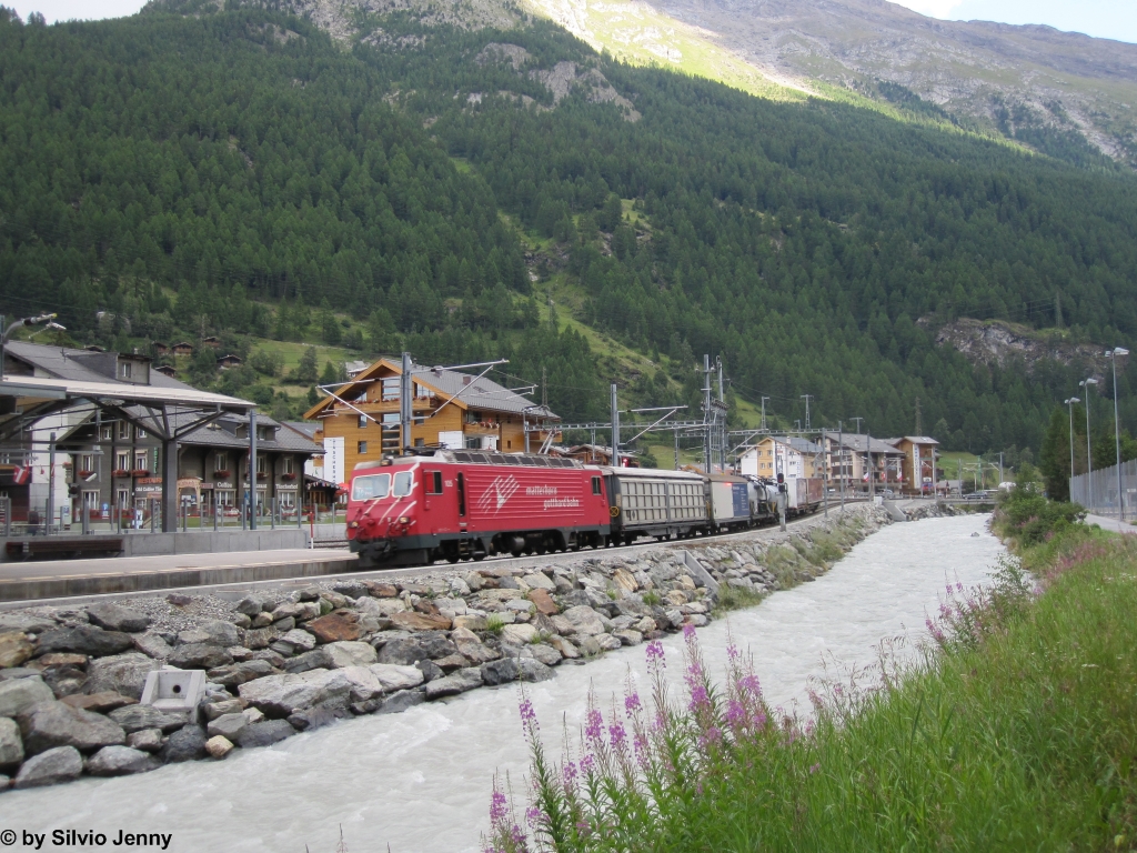 HGe 4/4'' 105 ''Oberalp/Alpsu'' am 2.8.2012 bei der Durchfahrt in Tsch mit einem Gterzug.