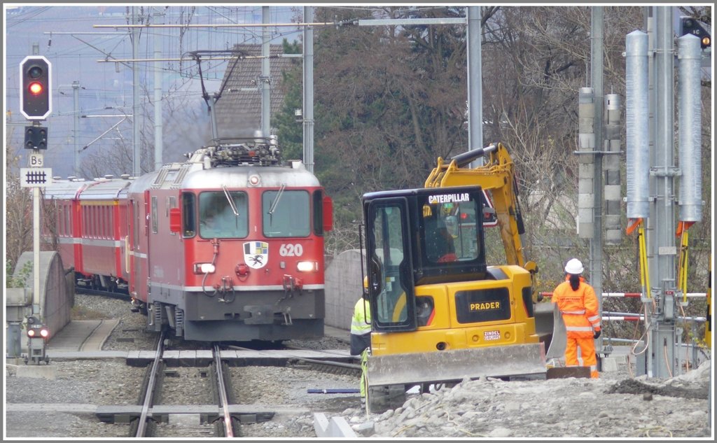 In Landquart RhB werden die Bahnsteige erhht und ein neues Perrondach gebaut. Die Sicherheitswrterin hat alle Hnde voll zu tun bei dem dichten Verkehr. RE1240 mit Ge 4/4 II 620  Zernez  fhrt ein. (26.11.2009)