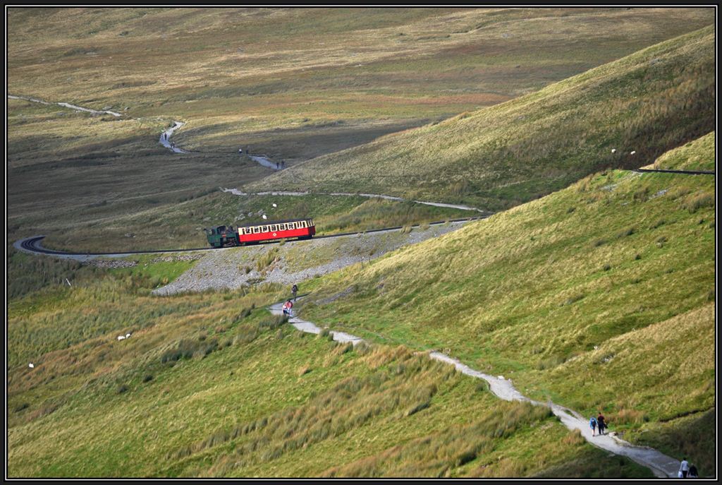 Lok 4  Snowdon  mit Jahrgang 1896 von SLM stampft mit dem nchsten Zug bergwrts.
Ebensoviele Wanderer wie Zugspassagiere nehmen den Weg zum hchsten Berg von Wales unter die eigenen Fsse. (06.09.2012)