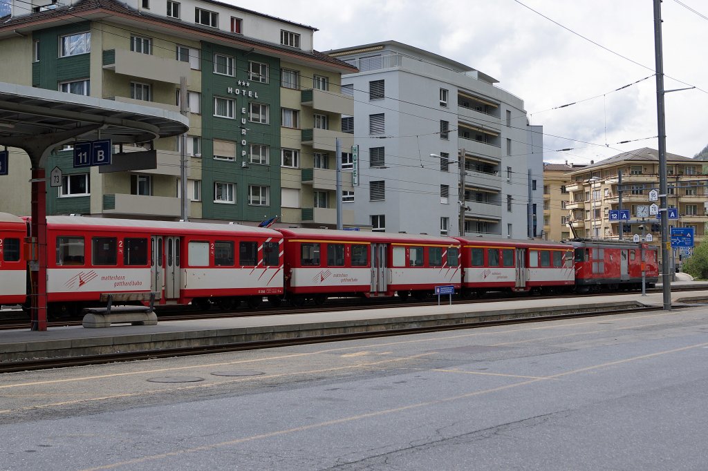 MGB: Mitteleinstiegpersonenwagen mit Baujahr 1947-SIG ex SBB Brnig sind bei der Matterhorn Gotthard Bahn nach wie vor unentbehrlich. Bei einem aus fnf Wagen bestehenden Personenzug wurden gleich drei solcher Wagen fr Reisende der ersten und zweiten Klasse eingereiht. Die Aufnahme ist am 4. Mai 2013 auf dem Bahnhofplatz Brig entstanden.
Foto: Walter Ruetsch  