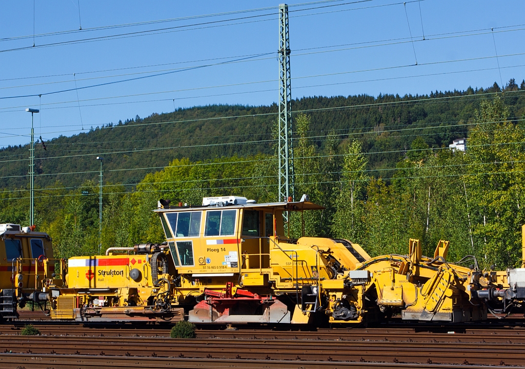 Plasser & Theurer Schnellschotterplaniermaschine SSP 110 SW   Ploeg 14  (Schweres Nebenfahrzeug Nr. 97 16 46 509 18-4)  der Niederlndischen Fa. Strukton Rail b.v. mit einer Niederlassung in Kassel, abgestell am 08.09.2012 in Betzdorf/Sieg. Die Maschine wurde 2004 unter der Maschine-Nr. 758 gebaut.   

Techn. Daten:  Gesamtlnge ber Puffer 17.050 mm  >  Anzahl der Achsen 2  >  Gewicht 44.000 kg  >  Max. Eigenfahrgeschwindigkeit 100 km/h   >  Leistung 400 kW  (Deutz BF8M 1015C Motor)  >  Spurma 1.435mm  >  zugelassen fr Streckenklasse D2 oder hher.

Schotterpflge werden vor oder nach dem Stopfen des Gleises eingesetzt. Die Maschinen bewirken eine optimale Schotterverteilung und Formen das Profil des Schotterbettes. Dies ist notwendig fr den Seitenwiederstand des Schotterbettes.