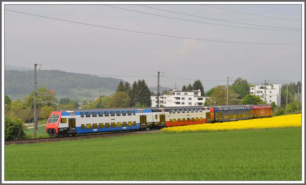 S9 18953 Zug - Uster in Urdorf Weihermatt. Diese 450er Komposition macht Werbung fr die verschiedenen Verkehrstrger des Zrcher Verkehrverbundes und zwar auf jeder Seite verschieden. Steuerwagen = VBZ Tram und Bus Stadt Zrich, 2.Wagen = Stadtbus Winterthur, 3.Wagen = VZO Verkehrsbetriebe Zrich Oberland und die Lok 450 fr die SBB. (28.04.2011)