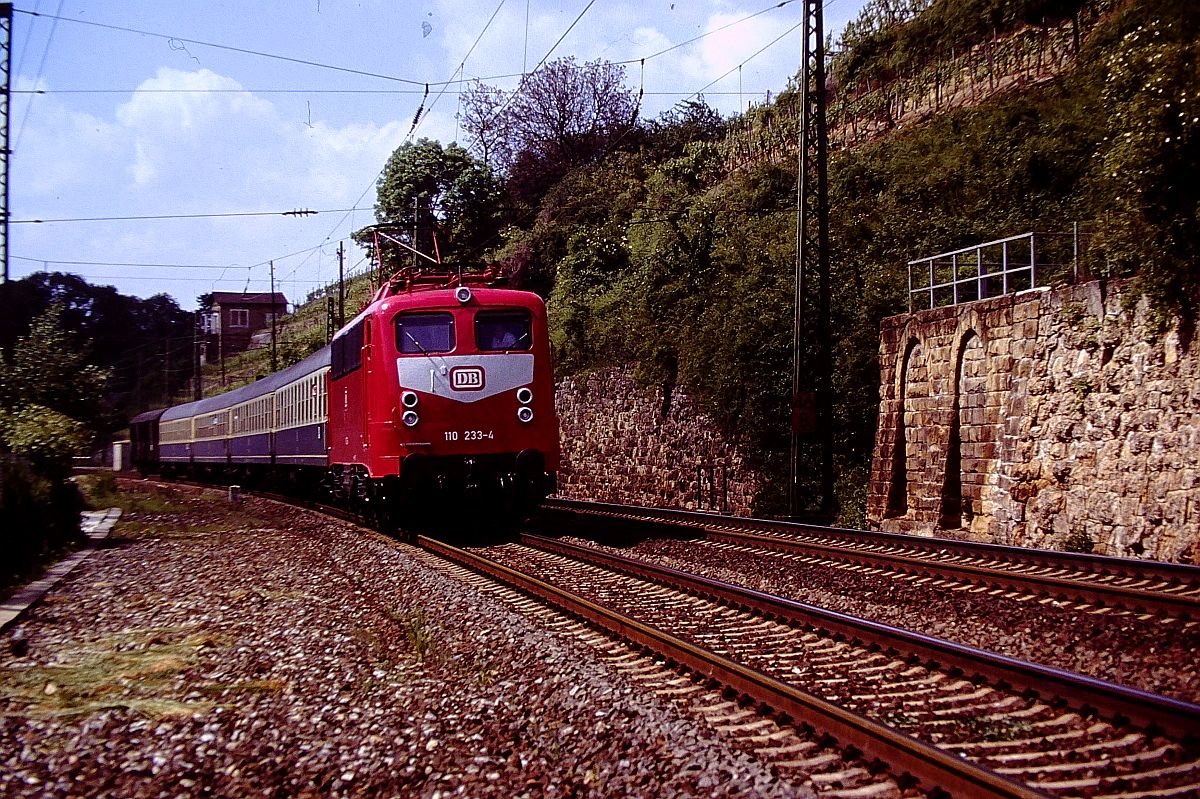 03.Juni 1991 kurz nach Haltepunkt Nordheim/Würrt 110 233-4 (seit 22.03.91 umlackiert) mit E 3056 TS -NWH nach Heilbronn  ( links bei Hecktometertafel 46,8 Mauer mit Geländer da Stand bis 1983 Stellwerk Nordheim/Württ )