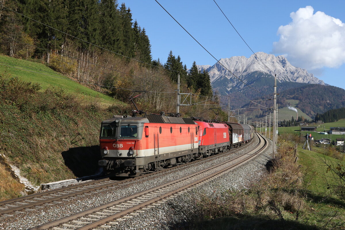 1144 113 und 1116 064 mit einem gemischten Güterzug auf dem Weg nach Wörgl. Aufgenommen am 29. Oktober 2024 bei Pfaffenschwend.