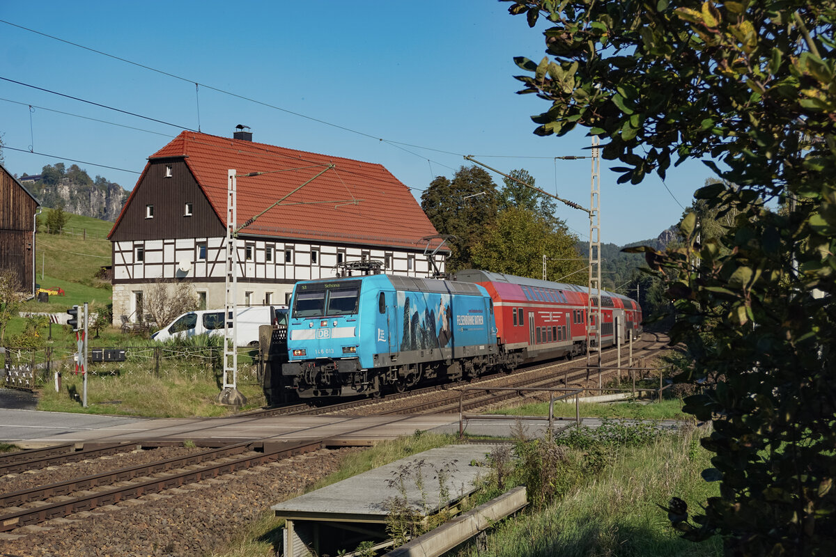 146 013  Felsenbühne Rathen  zog ihre S1 nach Schöna 09.10.2024 kurz vor halb 12 über den Bahnübergang an der Fotostelle in Rathen.