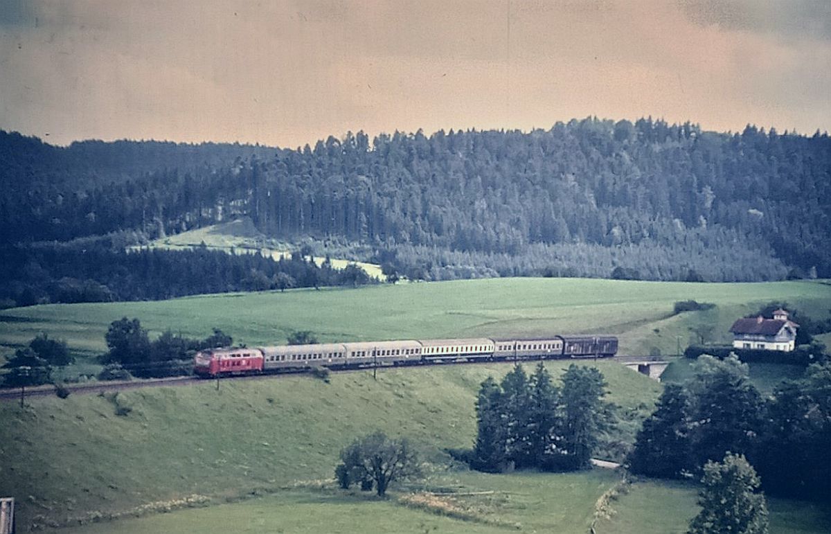 15.07.1992 kurz vor dem (Kappelsbergtunnel) und Bf. Gaildorfwest E 3105 mit drei Bn und einen Bm sowie am Schluß ein Habbiins Wagen gezogen von 218 382-0 nach Crailsheim .Murrrbahn wurde 1996 elektrifiziert für 50 Millonen DM.