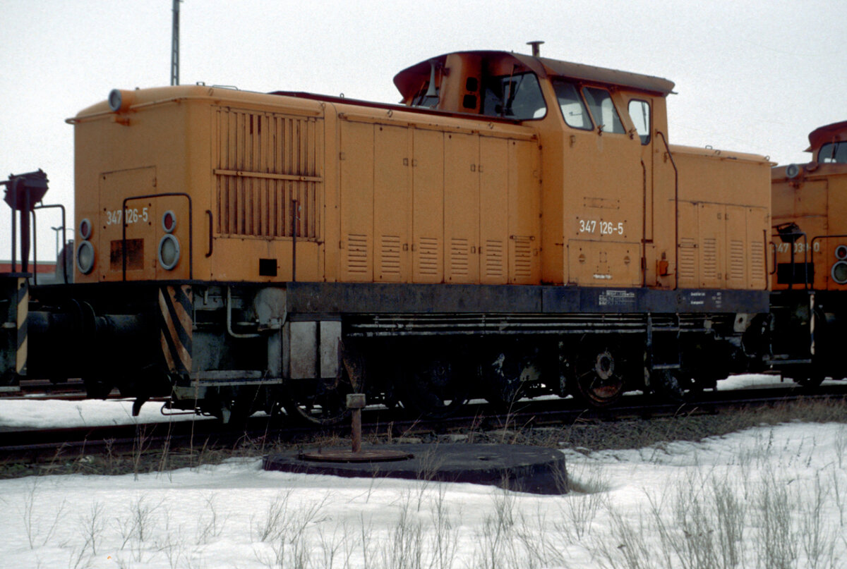 1981 von LEW an die DR mit der Tfz. Nummer 105 126 geliefert und 1986 auf russische Breitspur umgespurt, stand die bei der DB unter ihrer letzten Nr. 347 126 geführte Lok nach ihrer z-Stellung und Ausmusterung im Jahre 1994 am 17.03.1996 auf dem Abstellgelände des Fährhafens Mukran.