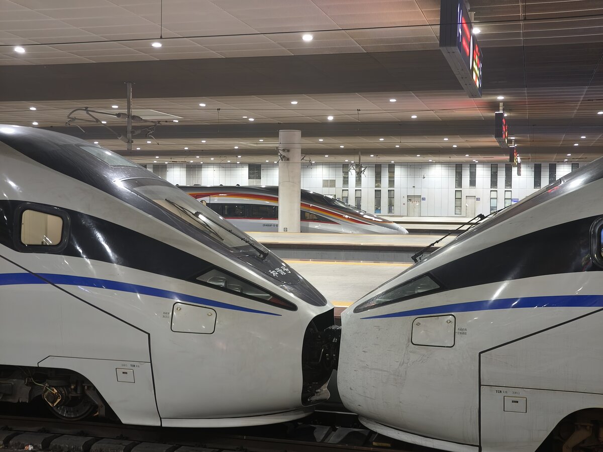 2024.10.19, CRH1A-A 1187, 1189, and unidentified CR400AF-S, ShenZhen North Station. While 1187/1189 hugging each other, poor 400AF-S hiding behind poles. This newly born 4 months old design was introduced since June 2024 branding  Tech Advanced Intelligence  Fuxing, with livery 瑞龙智行 (I dare translate it as  Auspicious Loong's Intelligence Journey ). This one was a 02xx series, must be from CR GuangZhou's GuangZhou Depot.
///
2024.10.19, CRH1A-A 1187, 1189 und nicht identifiziertes CR400AF-S, ShenZhen North Station. Während 1187/1189 sich gegenseitig umarmen, versteckt sich der arme 400AF-S hinter Masten. Dieses neugeborene, 4 Monate alte Design wurde im Juni 2024 unter der Marke „Tech Advanced Intelligence“ Fuxing eingeführt, mit der Farbgebung 瑞龙智行 (ich wage es zu übersetzen als „Auspicious Loong's Intelligence Journey“). Dies war eine 02xx-Serie, sie muss aus dem GuangZhou-Depot von CR GuangZhou stammen.