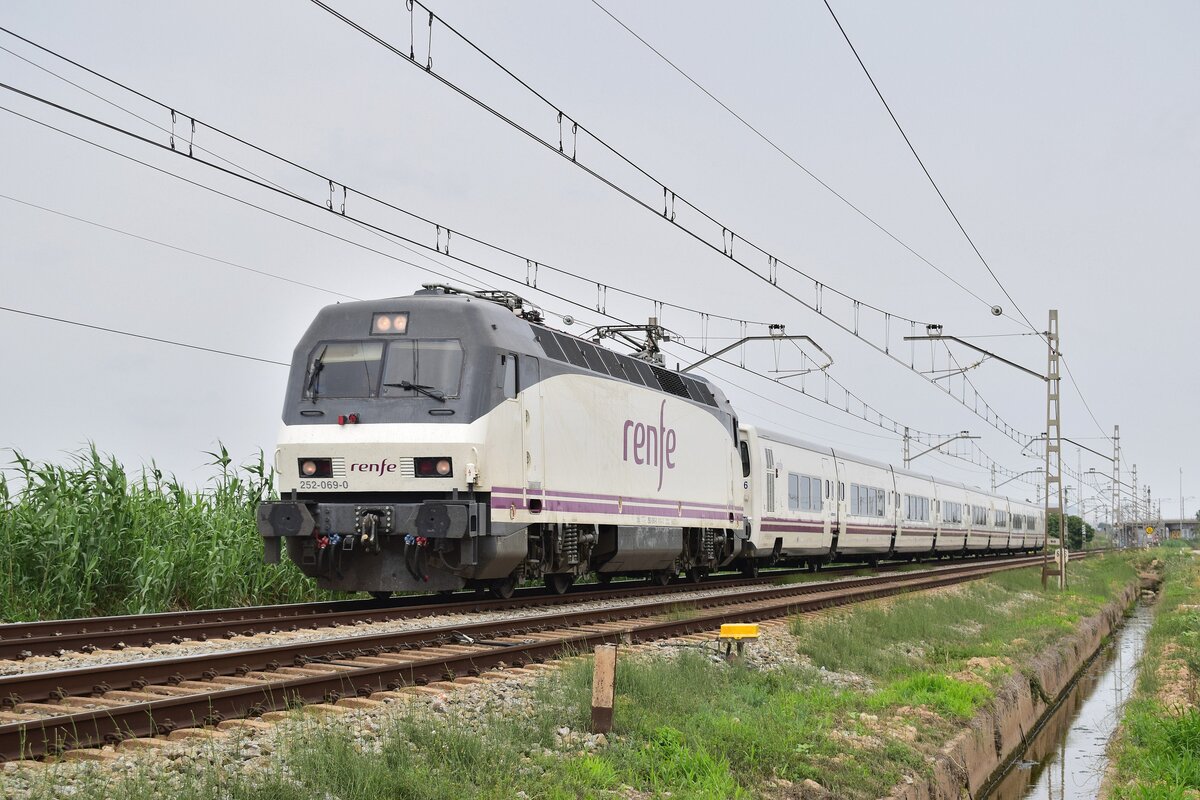 252 069-0 ist mit einem Talgo Intercity auf den Weg nach Valencia. Hier durchfährt er die Felder von Viladecans.

Viladecans 19.06.2024