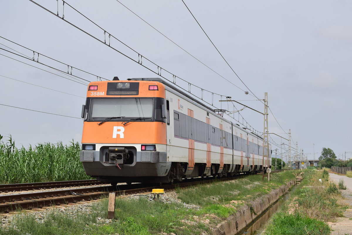 446 357 fährt von Sitges kommend Richtung Barcelona. Hier ist er bei Viladecans unterwegs. 
Viladecans 19.06.2024