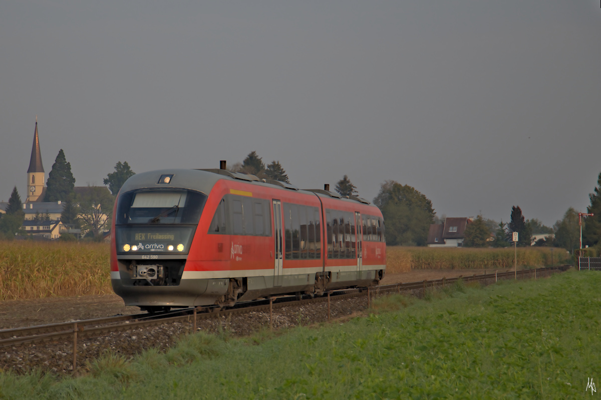 Am einem nebeligen Spätsommermorgen fährt der Triebwagen 642 590 gerade aus Mattighofen Richtung Salzburg und weiter nach Freilassing aus. Am linken Bildrand die Kirche von Mattighofen. (13.09.2020)