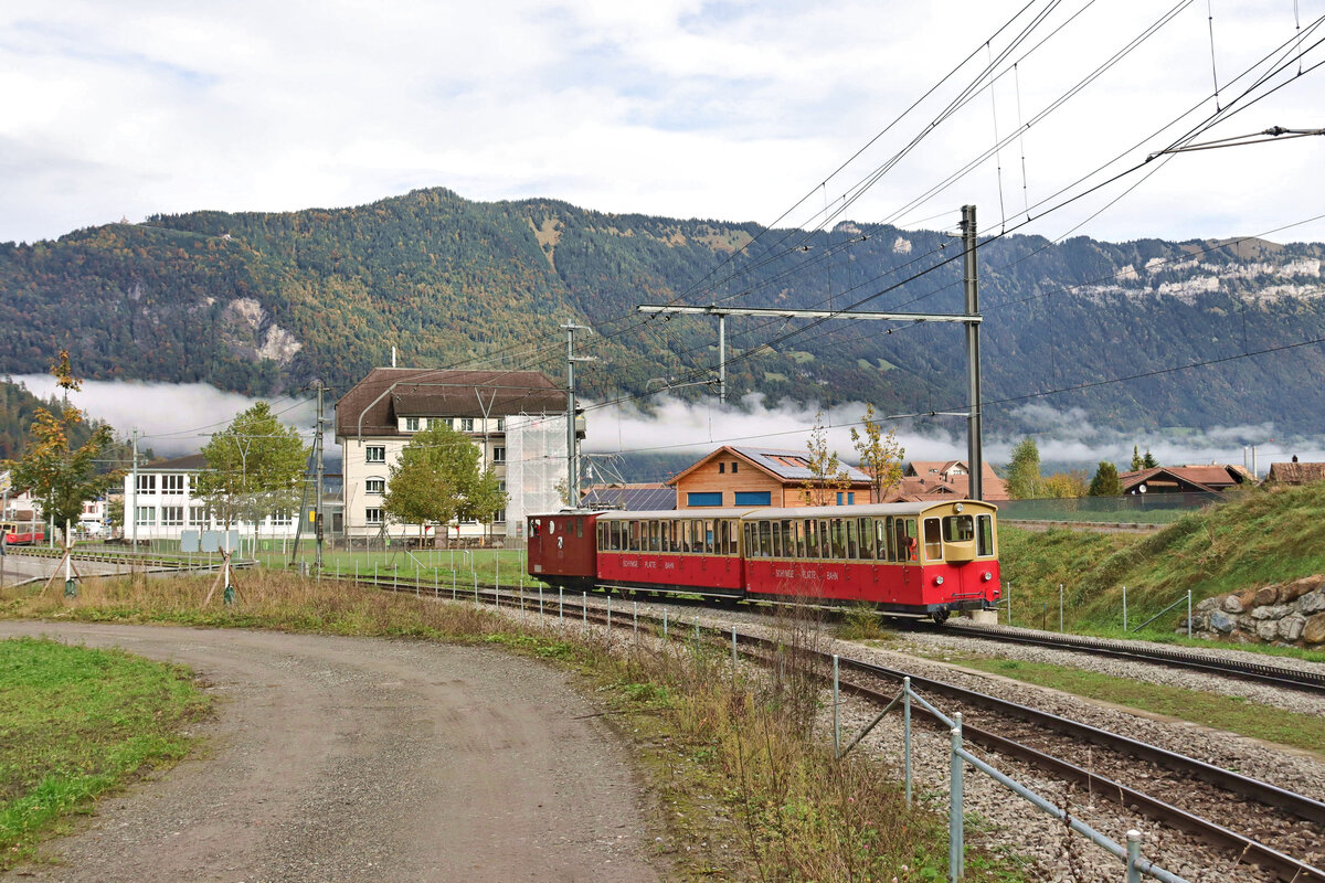 An einem schönen Herbsttag kurz vor Saison-Ende lichten sich die Nebel, und zwei vollbesetzte Züge der SPB machen sich zur Schynigen Platte auf. Auf der noch flachen Strecke neben der Berner Oberland Bahn kriecht SPB Lok 18 mit den beiden Wagen 41 und 42 (1992) voraus auf die 25 Promille-Steigung zu. Wilderswil, 9. Oktober 2024  