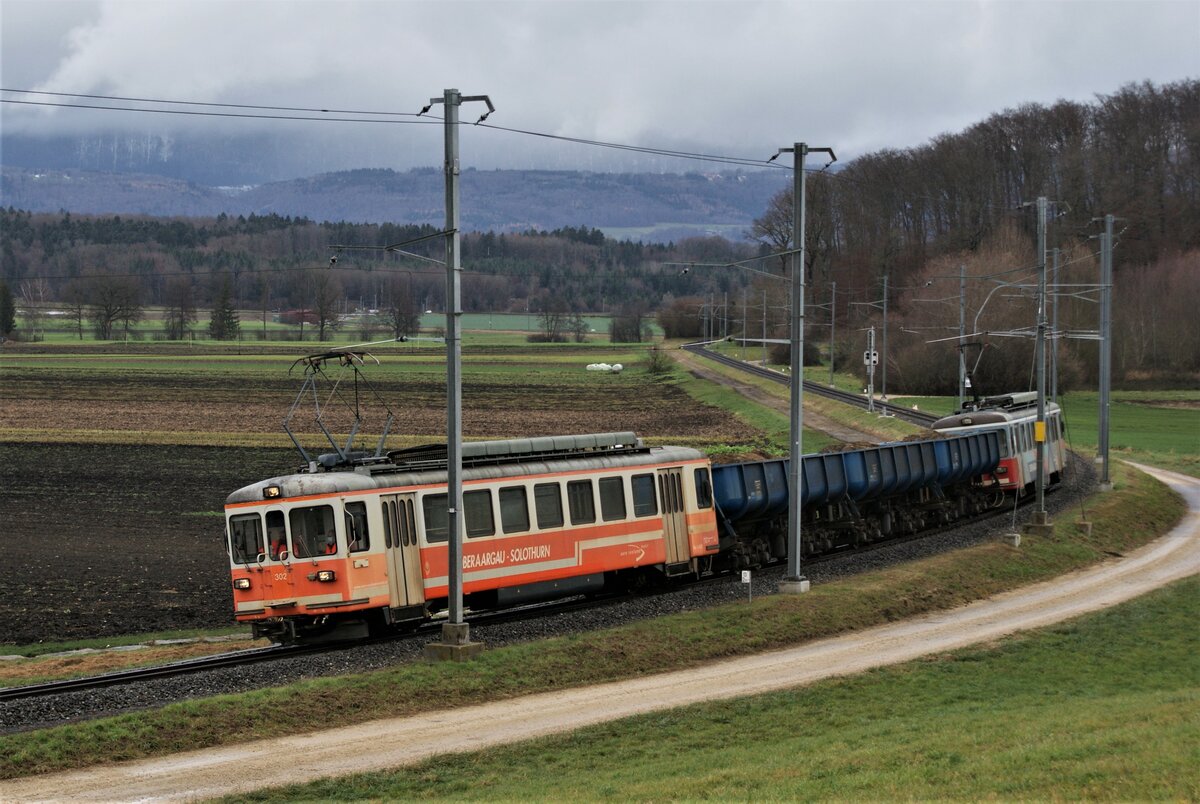 ASM BTI Aare Seeland mobil AG Biel-Täuffelen-Ins-Bahn: Be 4/4 302 + Fa 572 + Fa 571 + Fa 576 + Be 4/4 304, Zug 8250 Sutz-Finsterhennen, Siselen, 2. Dezember 2021. Auf dieser Aufnahme lässt sich der s-förmige Streckenverlauf bis zur Haltestelle Lüscherz und der Einfahrt in den Hagneckwald zurückverfolgen.