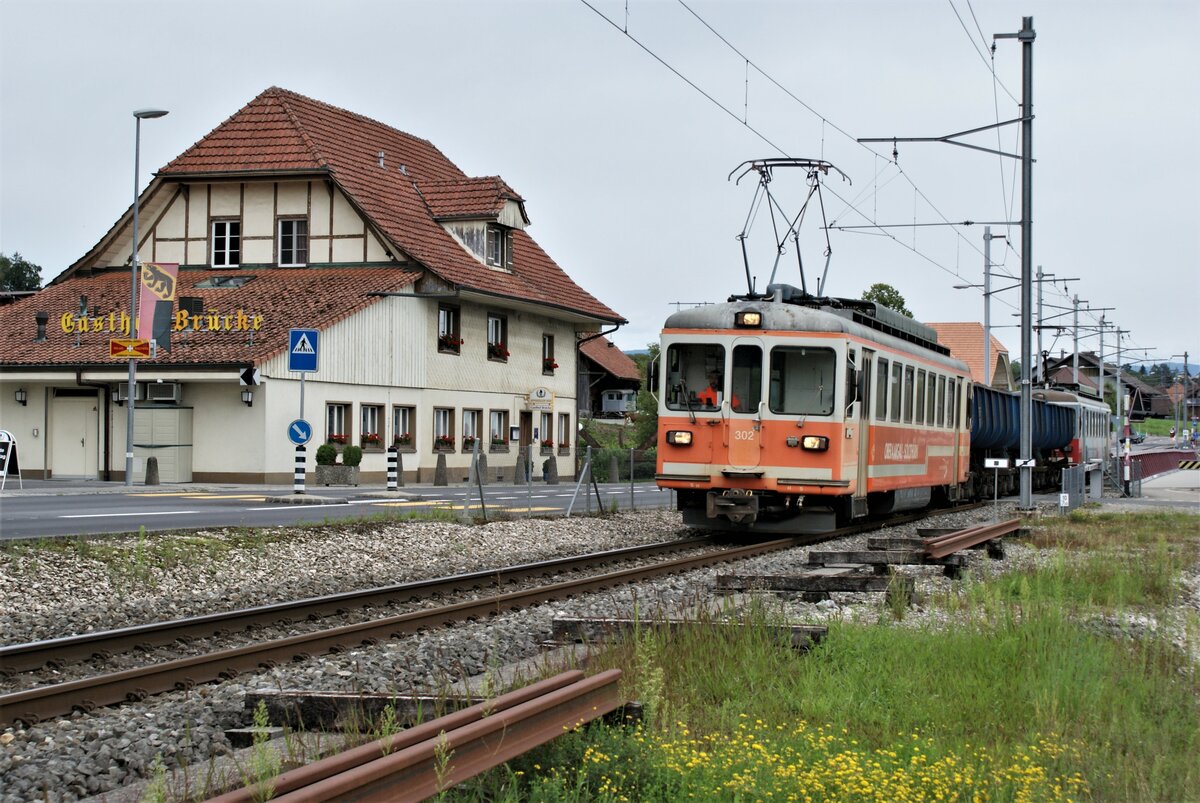 ASM BTI Aare Seeland mobil AG Biel-Täuffelen-Ins-Bahn: Be 4/4 302 + Fa 572 + Fa 571 + Fa 576 + Be 4/4 304, Zug 8286 Sutz-Finsterhennen, Hagneck, 9. August 2021. Der Zug hat eben die Brücke über den Hagneck-Kanal verlassen. Der Gasthof Brücke steht direkt am Kanaleinschnitt.