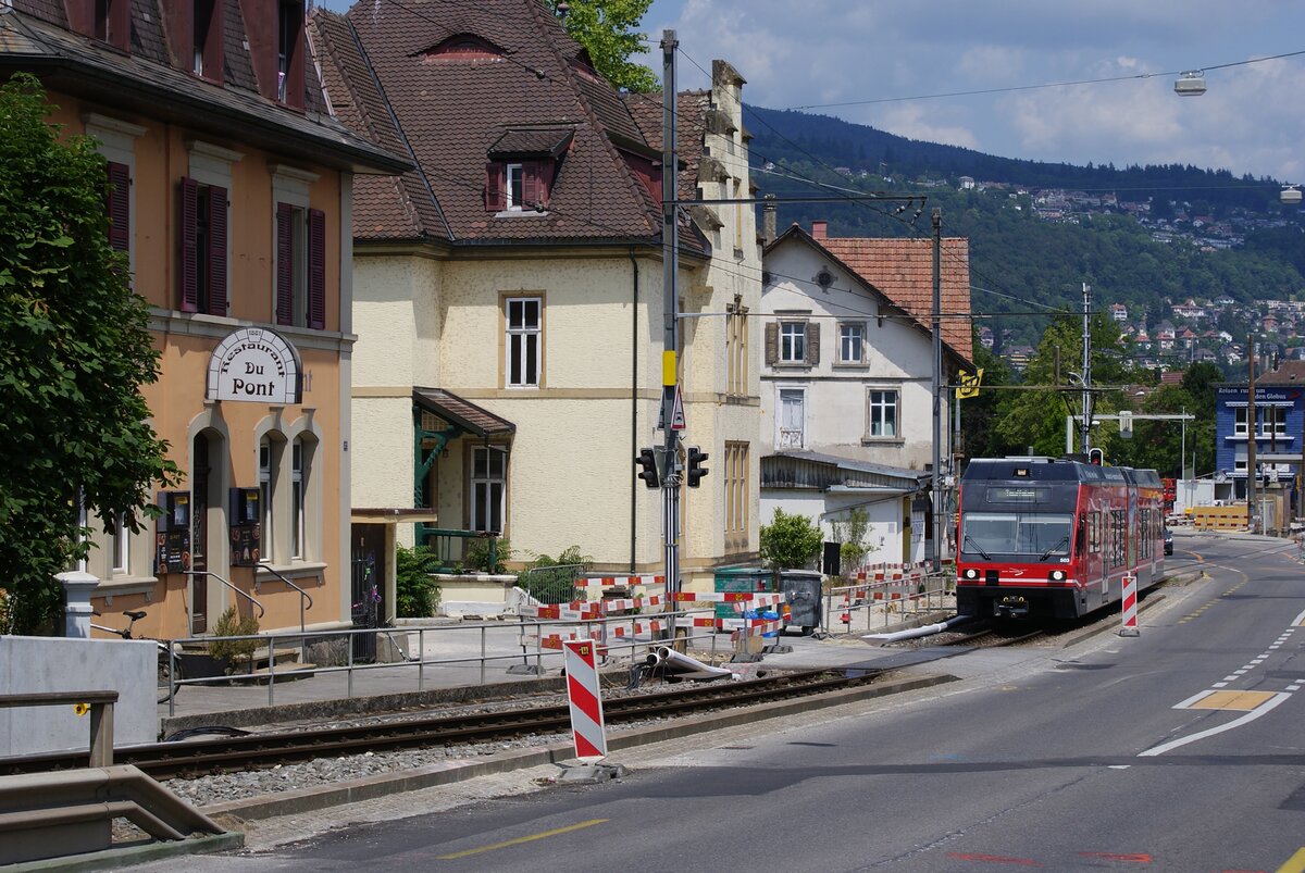 ASm BTI Aare Seeland mobil AG Biel-Täuffelen-Ins-Bahn: GTW 503 ( Kurzzug ), Zug 8068 Biel-Täuffelen, Nidau, 16. Juni 2023. Standort des Fotografen: Beginn der Brücke über den Nidau-Büren-Kanal. Die Zufahrten für Fahrzeuge zu den drei Liegenschaften (links des Zuges) führen über die Gleise. Vor dem Restaurant du Pont endete einst das Bieler Tram. Mit der Eröffnung der Strecke Siselen-Nidau der Biel-Täuffelen-Ins-Bahn 1916 wurde die Tramlinie gekürzt und die Züge der BTI verkehrten vorerst bis und ab Kirche und Schulhaus im Städtchen Nidau. Erst nach dem Bau des heutigen SBB-Bahnhofes in Biel konnte die Strecke nach Biel verlängert werden (von der Station Nidau, diese in etwa heutiger Lage, bis an die Gemeindegrenze Nidau-Biel mit eigener Trasse). Die Veränderungen in Nidau lassen sich mit den Karten der Landestopographie (mit nachführungsbedingtem Verzug) nachvollziehen (vgl. https://map.geo.admin.ch; Zeitreise 1916, 1918, 1930, 1993 ...).   