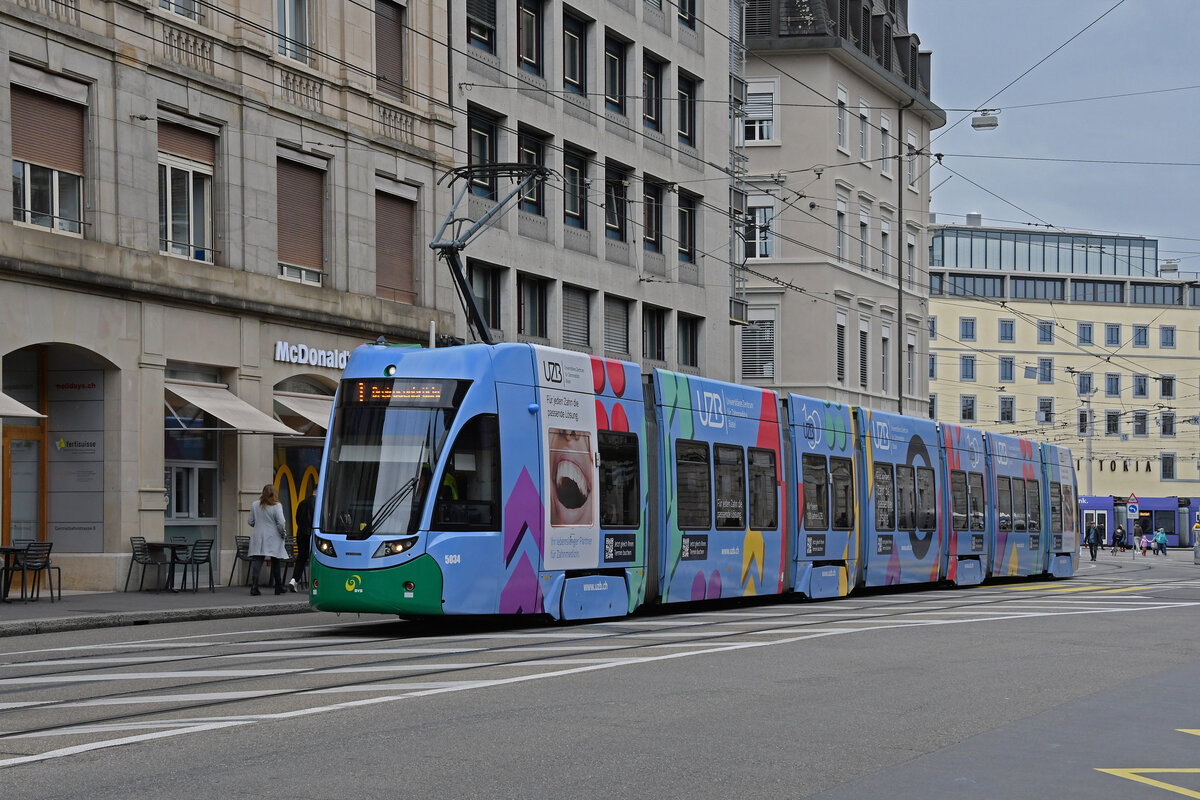 Be 6/8 Flexity 5034 mit der Werbung für Universitäres Zentrum Basel für Zahnmedizin (UZB), auf der Linie 1, fährt am 27.05.2024 zur Haltestelle Markthalle. Hat eine grüne Front wegen einer Kollision.