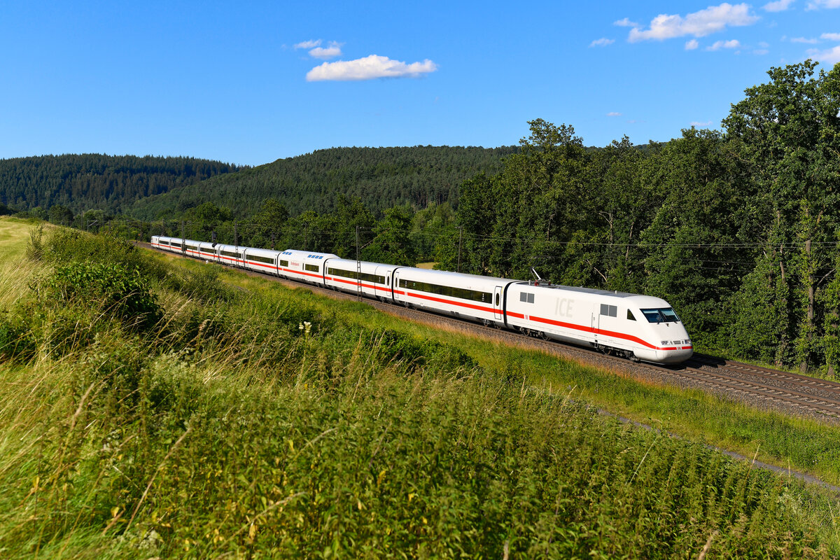 Bei gepflegten Garnituren des ICE 1 betätige ich inzwischen gerne den Auslöser, denn die Hochgeschwindigkeitszüge der ersten Generation fahren unweigerlich dem Ende ihrer Nutzungsdauer entgegen. Der hier gezeigte 401 061 hat erst wenige Tage zuvor die Abnahme nach dem zweiten Re-Design absolviert. Dabei wurde der ICE auf neun Mittelwagen verkürzt. Darüber hinaus wurde eine Revision der Antriebstechnik vorgenommen, ein neues Fahrgastinformationssystem installiert, mehr Gepäckstauraum vorgesehen sowie neue Sitzbezüge und neue Teppichböden eingebaut. Somit ist Tz 0161 nochmal fit gemacht für einen Einsatz bis Ende des Jahrzehnts. Am 28. Juni 2024 begegnete er mir bei Bernhards im osthessischen Haunetal. Welche Zugfahrt das allerdings war, bleibt unklar. 401er kommen um die Aufnahmezeit planmäßig nicht die Nord-Süd-Strecke entlang. 