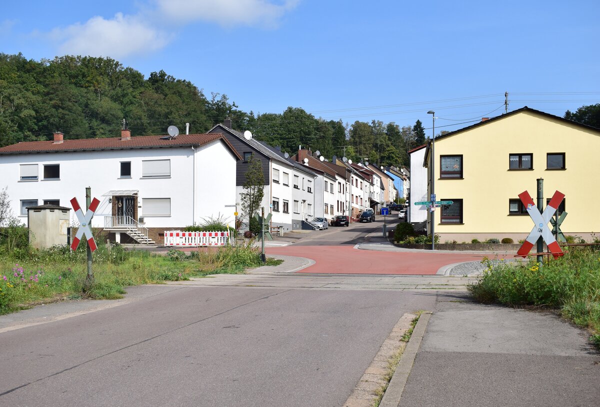 Blick auf den Bahhnübergang Denkmalstraße von Differten nach Überherrn. Der Verkehr auf der Strecke Völklingen - Überherrn - Thionville wurde schrittweise ab 1972 eingestellt. 1972 erfolgte die Einstellung auf dem Abschnitt Überherrn – Grenze Hargarten. 1992 erfolgte die Einstellung des Personenverkehrs auf dem Abschnitt Überherrn - Völklingen. 1995 wurde die Oberleitung abgebaut. 2003 wurde der Verkehr entgültig eingestellt und die Strecke stillgelegt. 2003 pachtete Mosolf die Strecke für den Güterverkehr. 2016 wurde der Verkehr wegen Oberbaumängel eingestellt. Es gab bis jetzt immer wieder Vorschläge zur Reaktivierung welche bis heute nicht erfolgte. Da die Strecke nur stillgelegt und nicht entwidmet ist, ist hier eine Reaktivierung jedoch möglich. 

Überherrn 30.09.2023