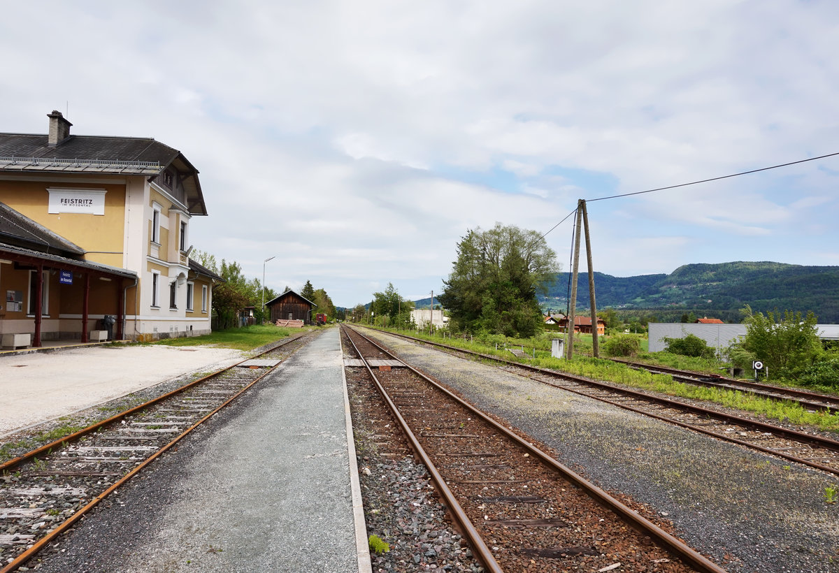 Blick auf den Bahnhof Feistritz im Rosental, am 5.5.2016.
Der Bahnhof besteht aus einem Ladegleis, zwei Bahnsteiggleisen, sowie einem Anschlussgleis für eine Firma (ganz rechts im Bild). Als einziges der vier Gleise wird nur noch das Gleis am Bahnsteig 1 befahren und das auch nur mehr Mo-Fr von einem einzigen Alibi-Zug von Rosenbach nach Klagenfurt Hbf um 6:42 Uhr.

Die Rosentalbahn wird von Weizelsdorf bis Rosenbach, ebenso wie die Gailtalbahn, mit dem Fahrplanwechsel 2016/2017 dem Zielnetz 2025+ zum Opfer fallen.
Nachdem in Kärnten die SPÖ stärkste Partei wurde und diese die Gelder für Sanierungen auf der Rosentalbahn strichen, hatte die ÖBB sogar in Eigenregie Geld in die Hand genommen um die Langsamfahrstellen auszubessern und die Strecke dadurch aufzuwerten. Die Fahrzeit verkürzte sich dadurch sogar um sagenhaft 40 Minuten! Dieses Unternehmen um die Strecke zu behalten war aber, wie man jetzt sieht, schlussendlich auch für die Katz.
Durch die Einstellung wird bei Bauarbeiten auf der Karawankenbahn, auch keine Möglichkeit mehr bestehen die Personen- aber auch die Güterzüge umzuleiten.
Unter anderem wird Einstellung der Bahn aber auch noch kräftig vom grünen Kärntner Landesverkehrsrat Rolf Holub unterstützt. Muss man schon sagen, das war wohl wieder eine richtig  grüne  Aktion von Herrn Holub. Da fragt man sich schon ob der in der richtigen Partei ist.