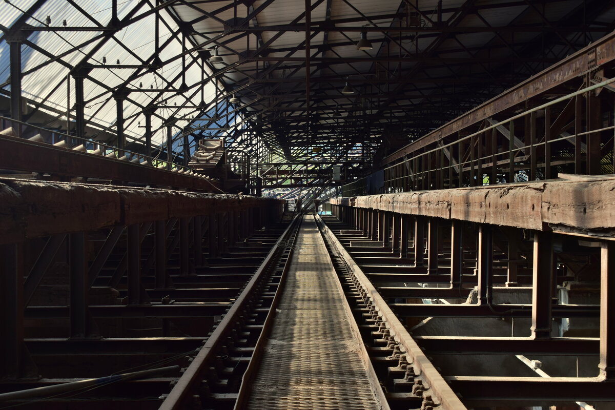 Blick auf ein Entladegleis in der Möllerhalle der Völklinger Hütte. Hier wurden die benötigten Rohmaterialien für die Eisenproduktion entladen und gelagert. Die Völklinger Hütte ist das weltweit einzige, vollständig erhaltene Eisenwerk aus Hochzeit der Industrialisierung. 1873 wurde die Hütte gegründet und 1986 wurde das Stahlwerk geschlossen. Seit 1994 zählt die Völklinger Hütte als UNESCO Weltkulturerbe. Man entschied sich damals die Hütte umzufunktionieren da ein Abriss der umfangreichen Anlagen viel zu teuer war. 

Völklingen 01.10.2023