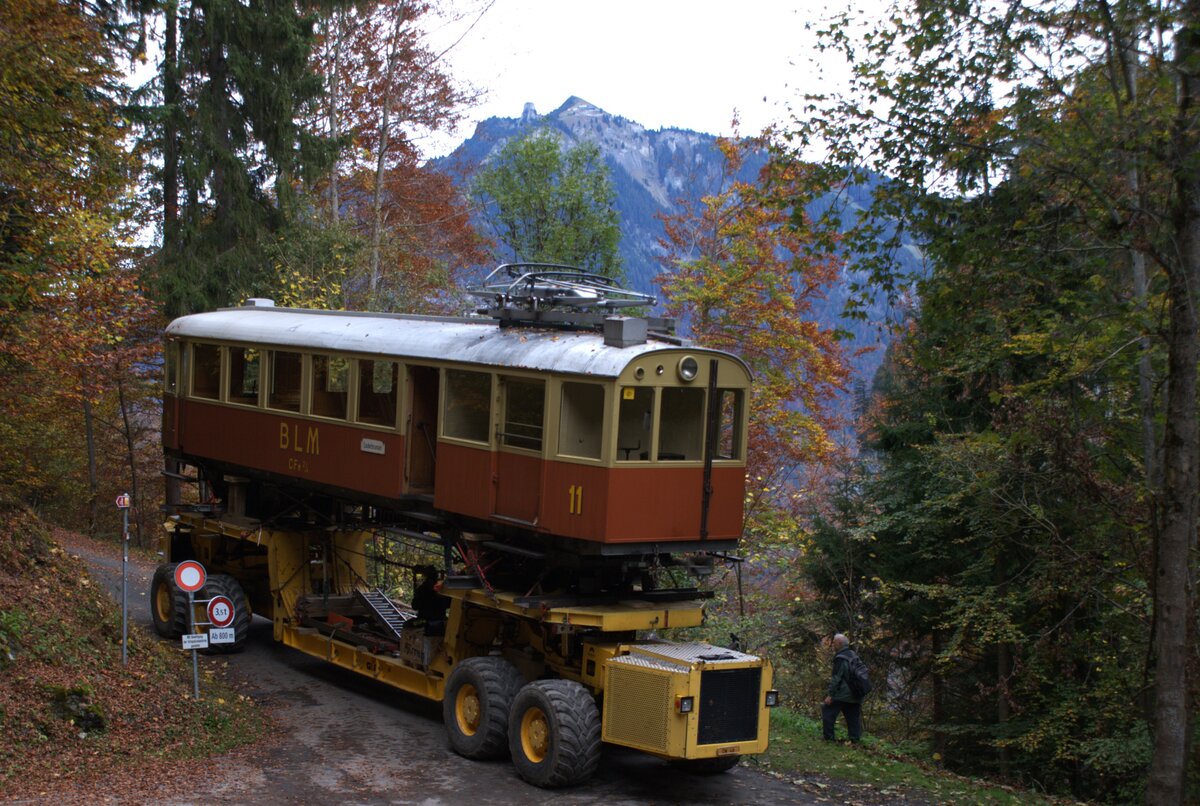 BLM Bergbahn Lauterbrunnen-Mürren: CFe 2/4 11 (SIG/MFO 1913), Taltransport Winteregg-Lauterbrunnen mit dem Spezialfahrzeug  Castor und Pollux , Einmündung des Weges Winteregg-Alpweg in die alte Isenfluhstrasse, Lauterbrunnen, 24.Oktober 2024. Nach vollzogener Spitzkehre und kurzer Rast fährt der Transport nun auf der alten Isenfluhstrasse talwärts. 