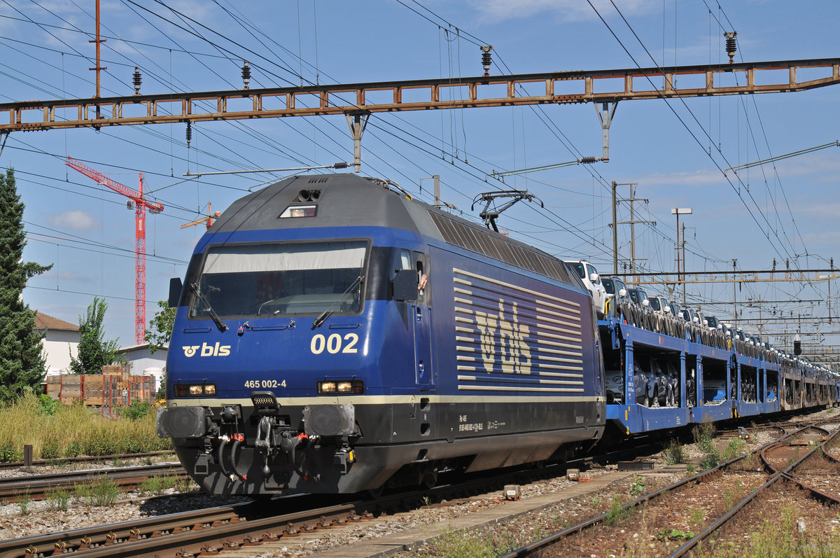 BLS Lok Re 465 002-4 durchfährt den Bahnhof Pratteln. Das abzweigende Gleis führt auf eine Strasse und in ein Industriegebiet, von wo aus auch diese Aufnahme am 03.08.2016 entstand.