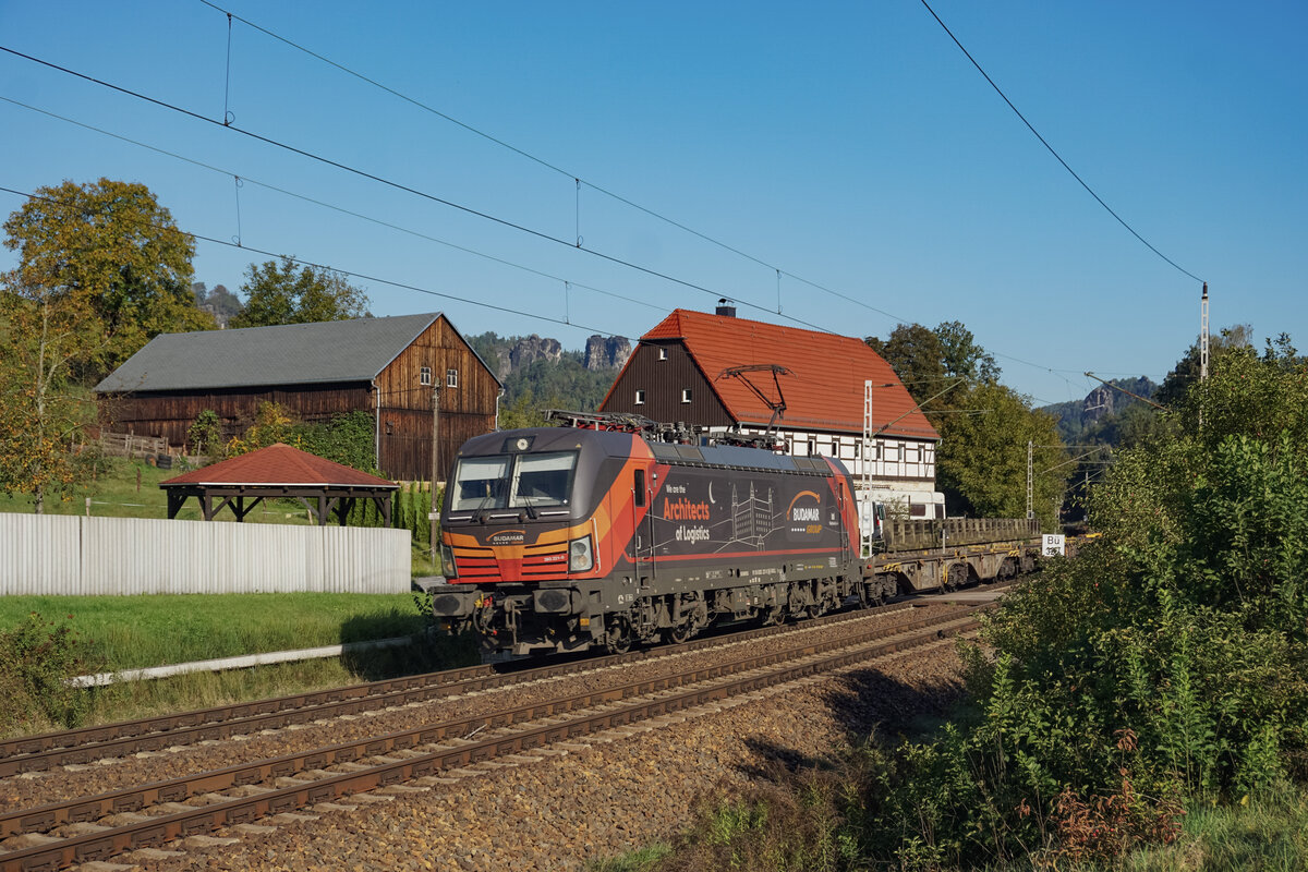 Budamar 383 221 mit einem kommplett leeren Containerzug am 09.10.2024 bei Rathen.