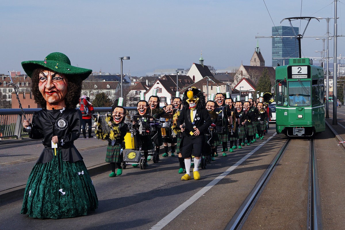 BVB während der BASLER FASNACHT 2014. Obschon während  den drey schenschte Dääg  nicht alle Linien auf den gewohnten Strecken verkehren, kommt es sehr oft zu Begegnungen zwischen Fasnachtscliquen und der BVB. Be 6/8 673 (Linie 2) und die  NUGGI SPUGGER  in  G R U E N beim Passieren der Wettsteinbrücke am 11. März 2014.
Foto: Walter Ruetsch