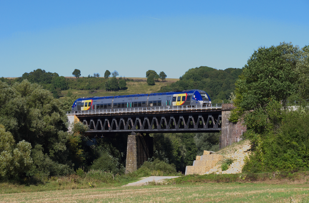 Dans la valle de la Sarre oder dort wo das  Krumme Elsa  auf Lothringen trifft.

Der Sommer war im Sdwesten zurck und wir muten einfach raus an die Bahnstrecke.
ber die Grenze nach Lothringen sollte es gehen, dabei vergit man oft, dass das  Krumme Elsa  fast bis ans Saarland reicht, knappe 7 Kilometer fehlen noch bei Siltzheim bis nach Deutschland, wie ein Stiefelabsatz reicht das  Krumme Elsa  hier nach Lothringen bis kurz vor Sarreguemines.

Unseren ersten Standort erhielt man frher  kostenlos , denn die alte Straenfhrung der D33 fhrte am Motiv vorbei.
Durch die Verlegung der Strae an der anderen Seite der Bahnlinie vorbei, mu man sich diesen Blick jetzt erarbeiten.

SNCF Ter X 76 564 ein AGC von Bombardier ist auf der Relation Sarreguemines - Sarre - Union unterwegs und berquert die Saar bei Wittring, das noch im Dpartement Moselle, also in Lothringen liegt.
Gleich erreicht der Triebwagen Kalhausen, dort teilt sich die Strecke nach Sarre - Union und nach Straburg.
02.09.2013
Ligne 161000 Mommenheim - Obermodern - Kalhausen - Sarreguemines