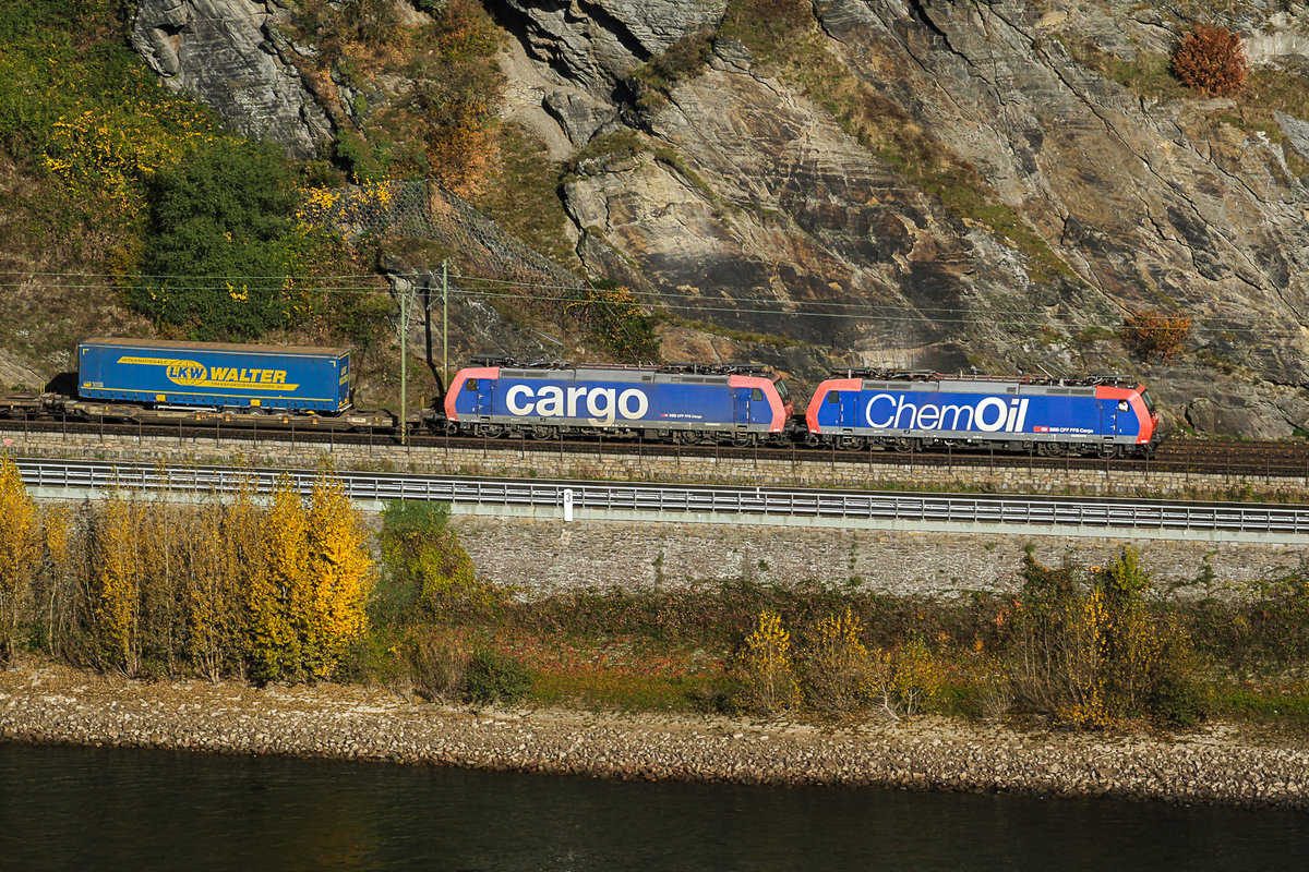 Das herbstliche Rheintal bei Oberwesel. Aus dem Rossteintunnel kommt der bunte Güterzug Richtung Schweiz am 02.11.2016. Gelichtet von der Burg Schönburg. Der Lokführer schnuppert frische Luft, oder raucht zum Fenster raus ?