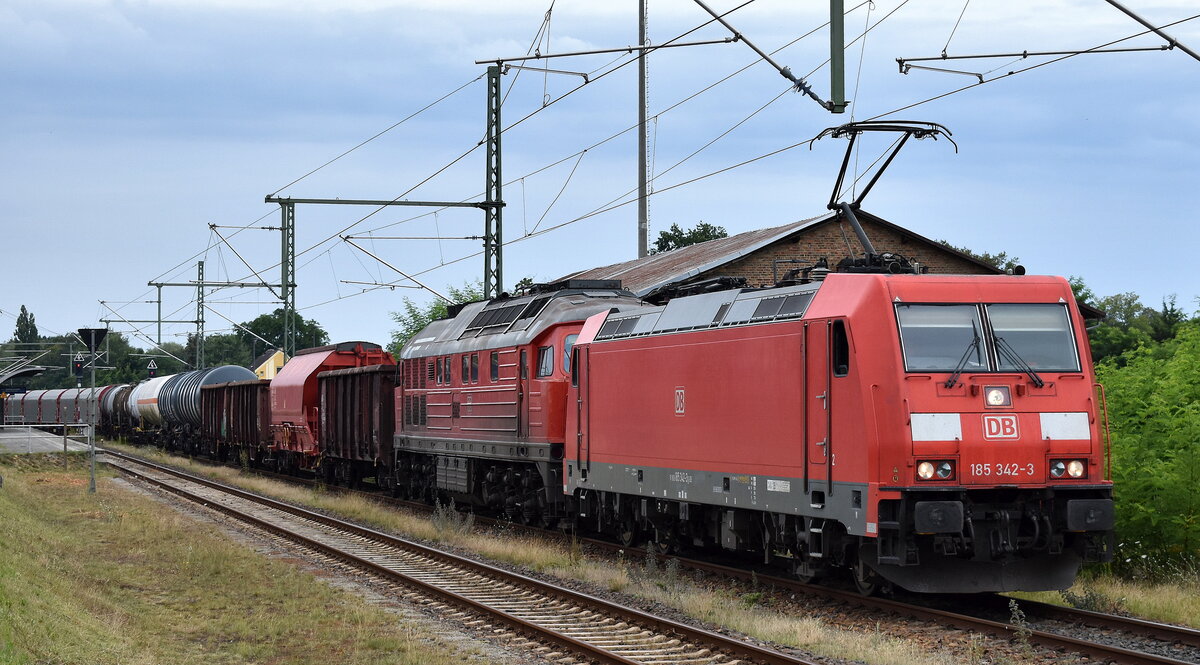 DB Cargo AG, Mainz mit ihrer   185 342-3  [NVR-Nummer: 91 80 6185 342-3 D-DB] mit  232 254-3  (NVR:  92 80 1232 254-3 D-DB ) und gemischtem Güterzug am Haken Richtung Rbf. Seddin am 26.07.24 Höhe Bahnhof Lübben (Spreewald).