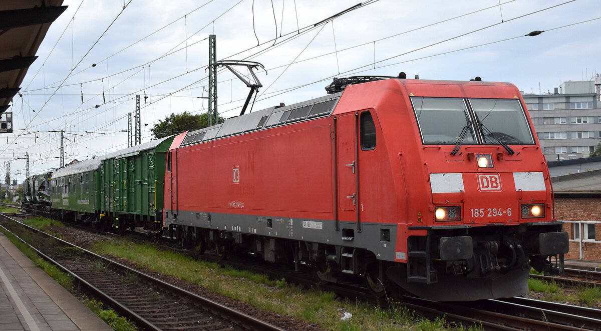 DB Cargo AG, Mainz mit ihrer  185 294-6  [NVR-Nummer: 91 80 6185 294-6 D-DB] und dem Tragschnabelwagen (Uaai 838) der Kübler Heavy Rail GmbH + Begleitwagen am Haken am 31.07.24 Höhe Bahnhof Magdeburg-Neustadt.