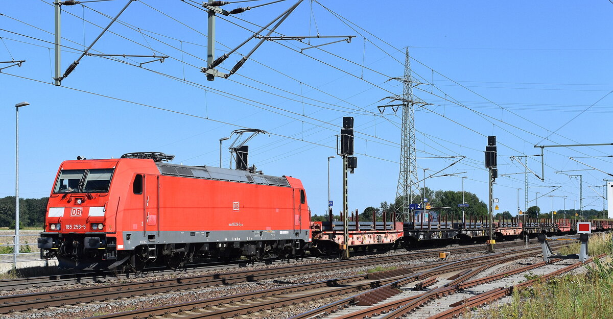 DB Cargo AG, Mainz mit ihrer  185 256-5  [NVR-Nummer: 91 80 6185 256-5 D-DB] und einem Ganzzug Drehgestell-Flachwagen mit Stahlbrammen beladen am 06.08.24 Durchfahrt Bahnhof Rodleben.