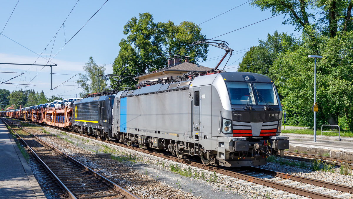 Die 91 80 6193 120  (Railpool) wurde im Juli 2023 neu abgeliefert und sogleich an Lokomotion vermietet. Hier befördert die Maschine am 15.07.2024 zusammen mit einer Maschine der Baureihe 189 einen Autotransportzug durch den Bahnhof Aßling in Richtung Rosenheim.