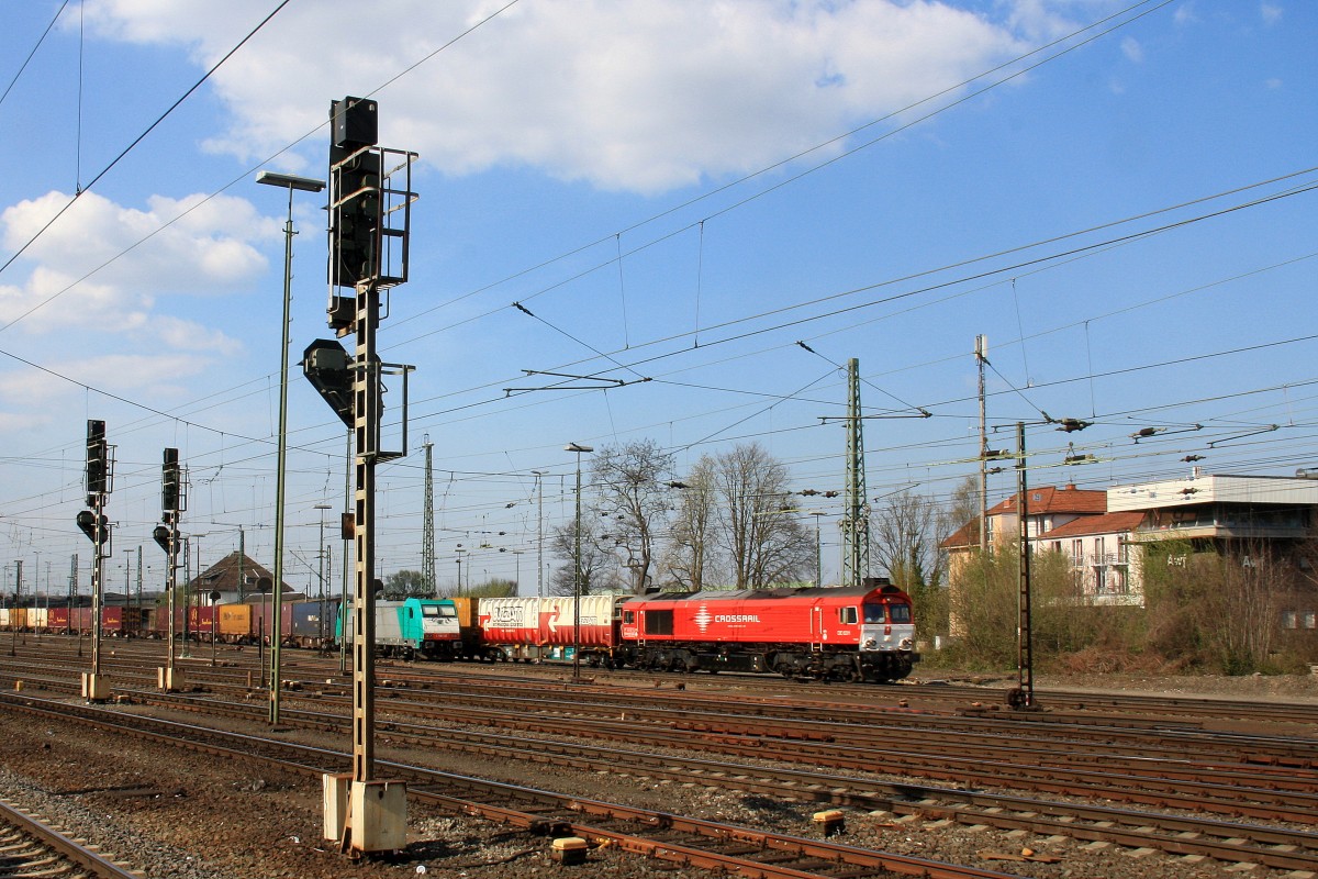 Die Class 66 DE6311  Hanna  von Crossrail fährt viel Gas mit einem langen Containerzug aus Segrate(I) nach Zeebrugge-Ramskapelle(B) bei der Ausfahrt aus Aachen-West und fährt in Richtung Montzen/Belgien,
und im Hintergrund steht eine E186 132 von Crossrail auf dem abstellgleis in Aachen-West. 
Aufgenommen vom Bahnsteig in Aachen-West bei schönem Frühlingswetter am 28.3.2014. 